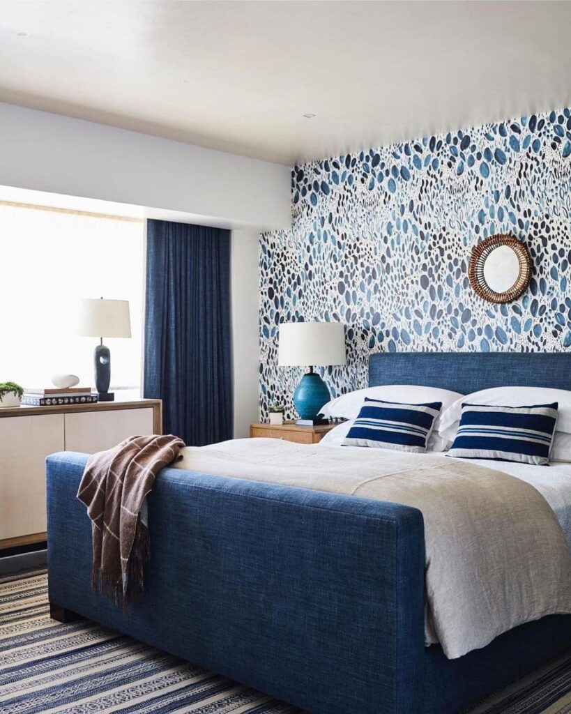 Blue patterned wallpaper, navy bed, coastal accents