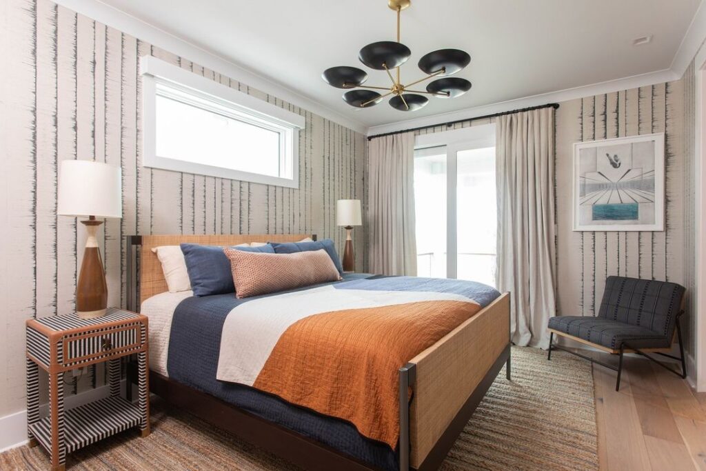 Modern bedroom with blue-orange bedding, striped wallpaper