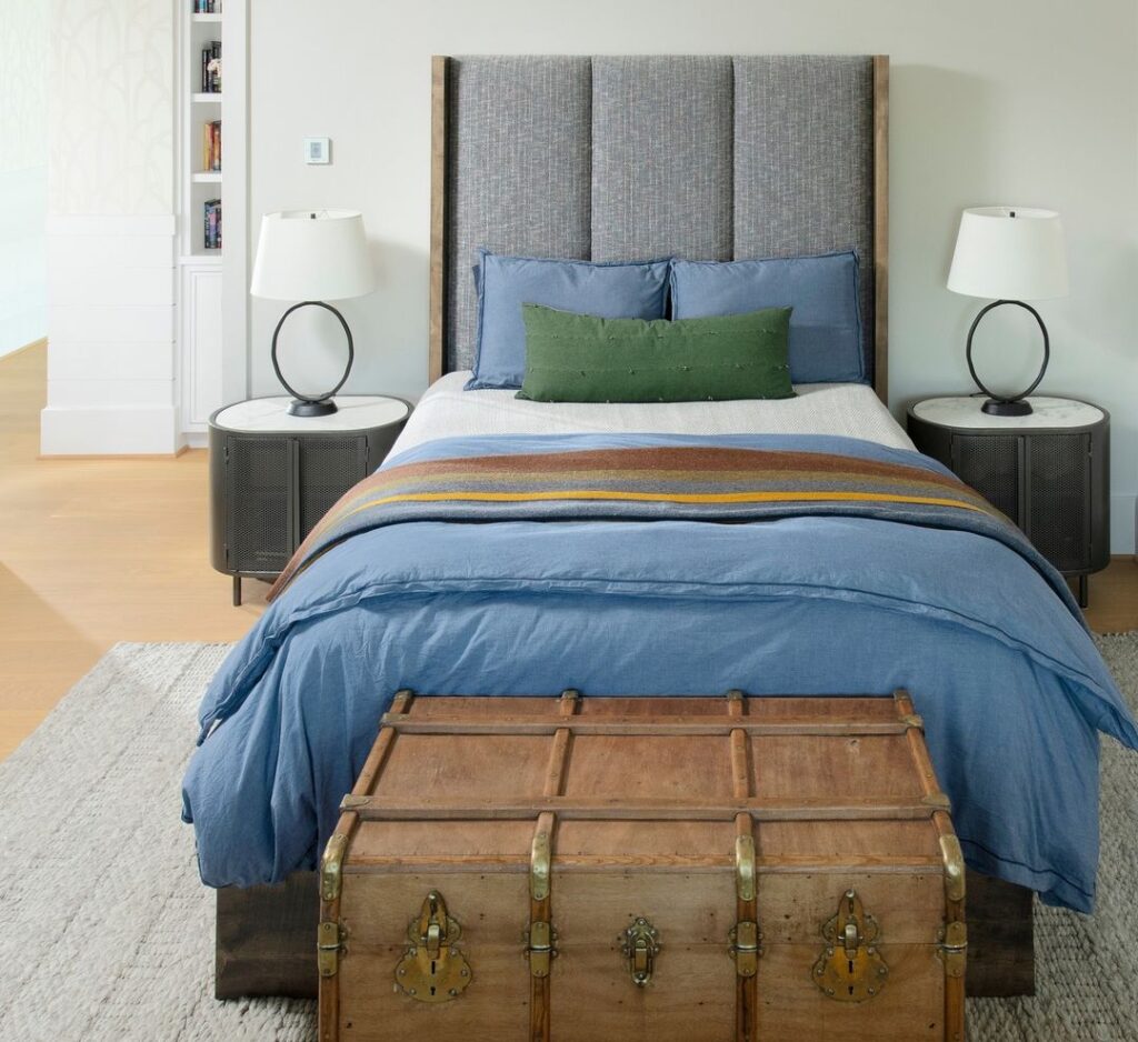 Modern bedroom with blue bedding and vintage trunk