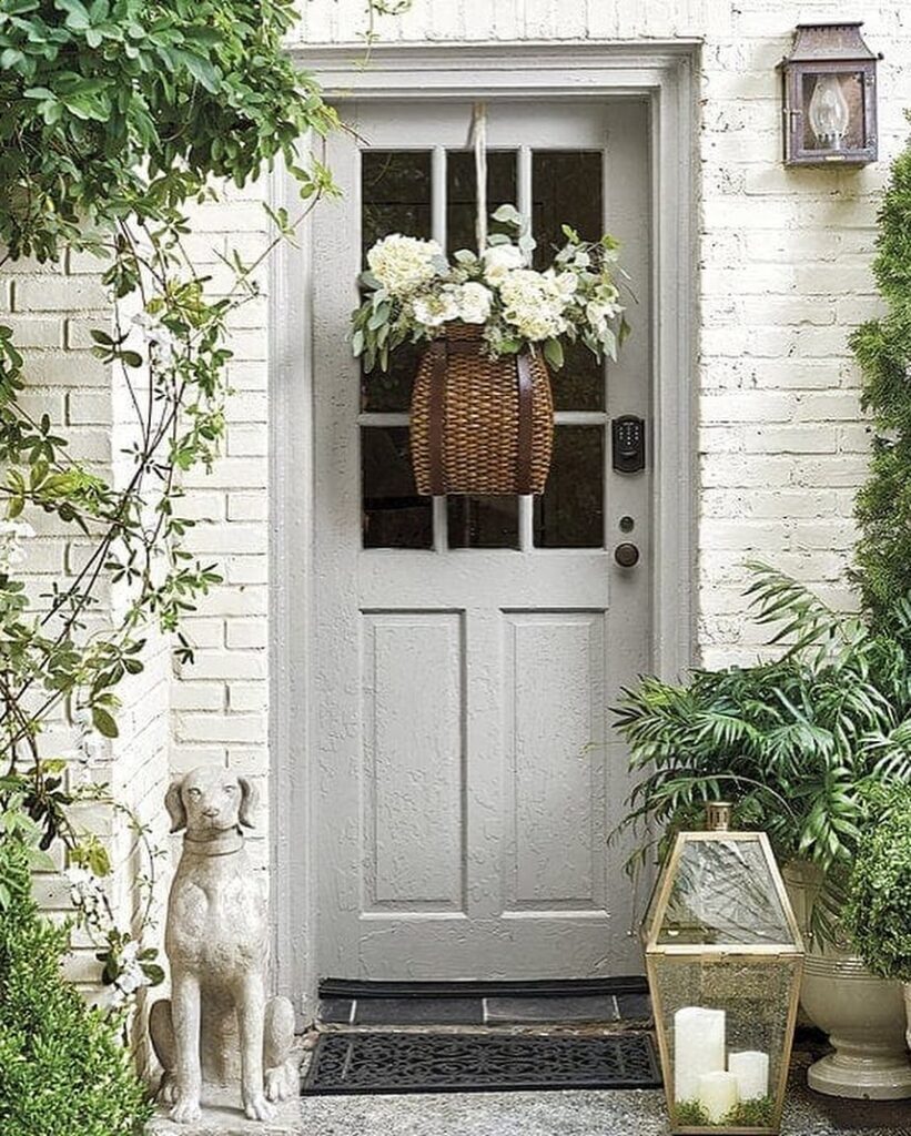 Gray door with hanging floral basket and greenery