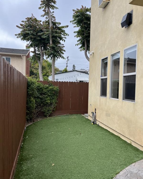 Small backyard with privacy fence and turf