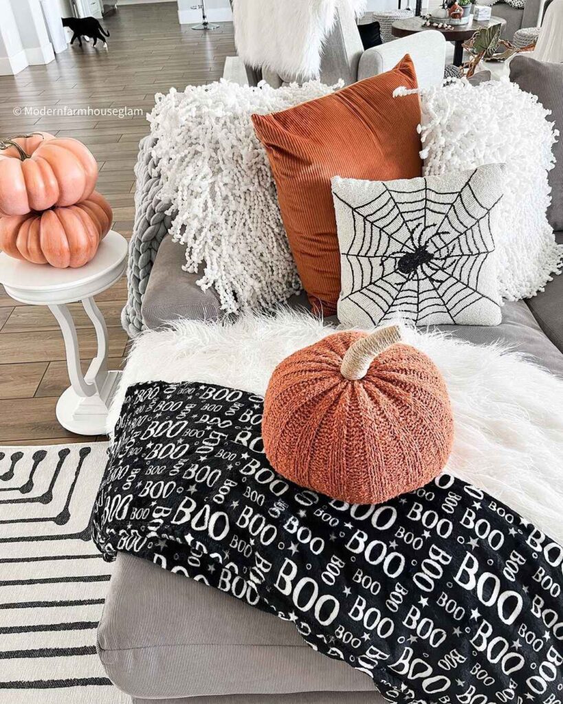 Cozy couch with Halloween pillows and pumpkins