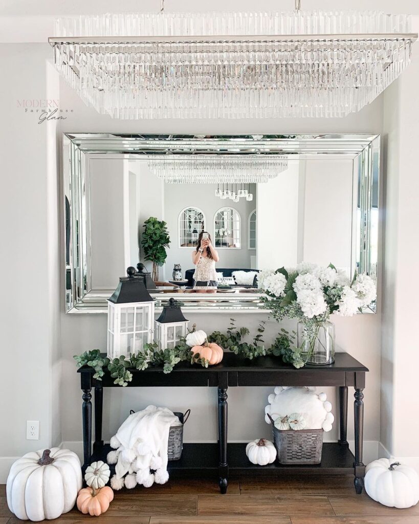 Elegant entryway with mirror chandelier and pumpkins