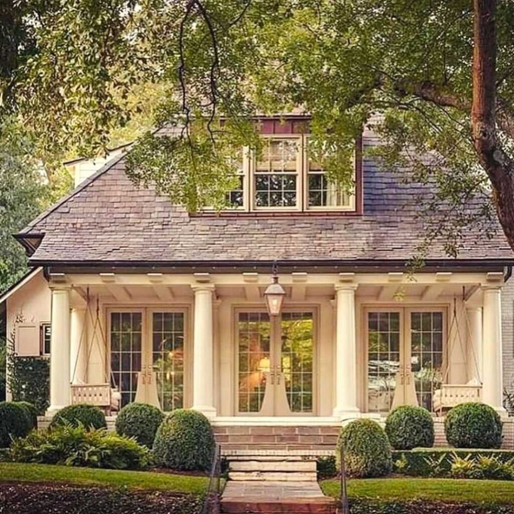 White porch with columns and manicured landscaping