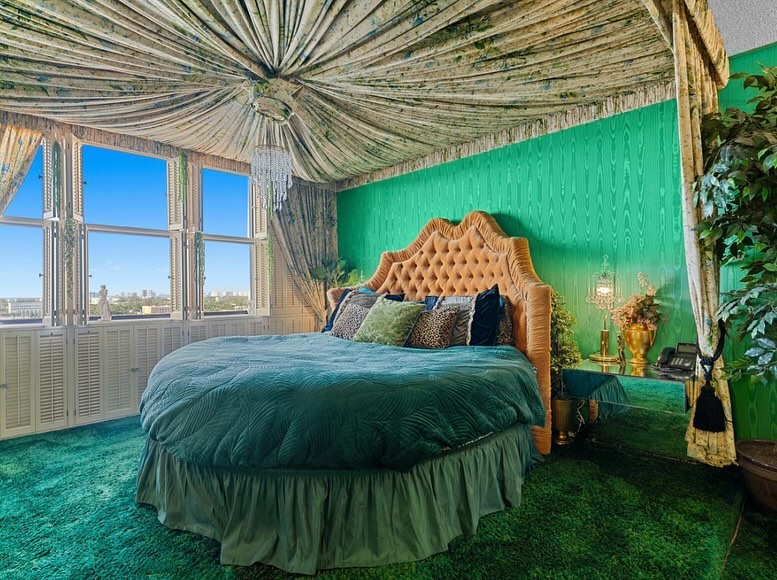 Green bedroom with draped ceiling, city view