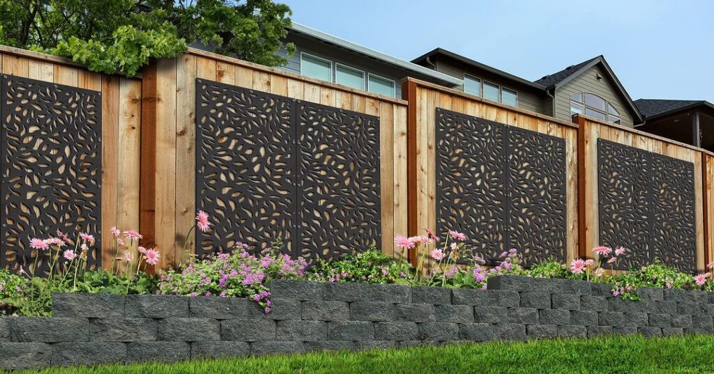 Decorative fence with floral cutouts above garden