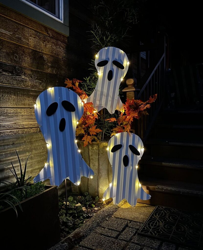 Lit-up striped ghosts, fall leaves, night