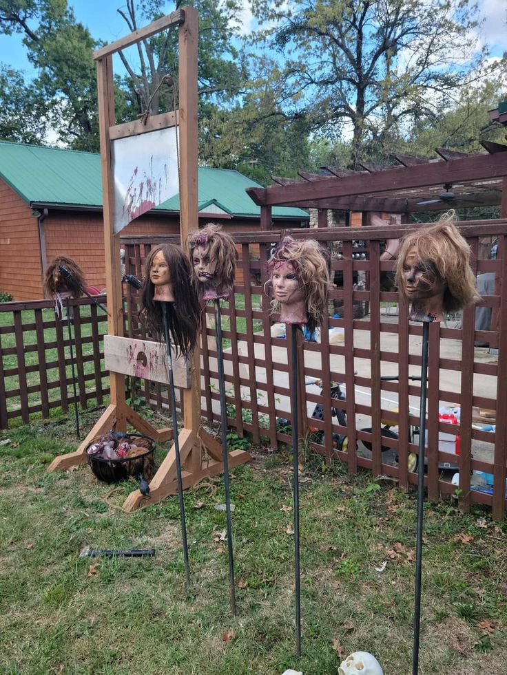 Mannequin heads on stakes lining backyard fence