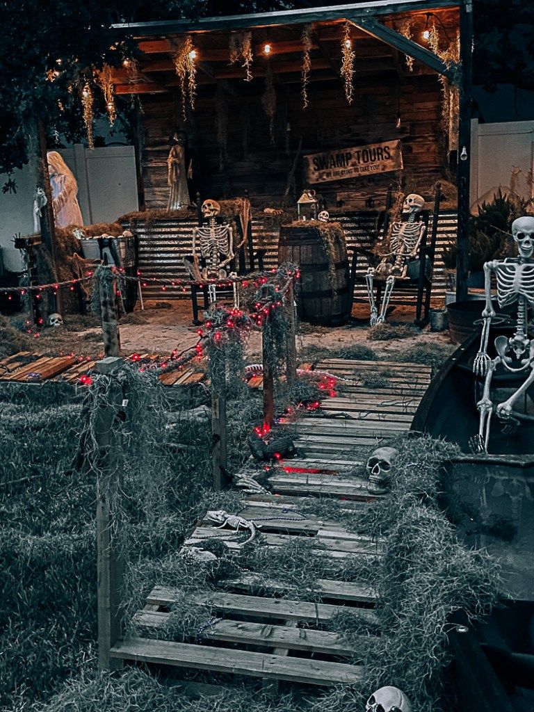 Spooky swamp-themed Halloween display with skeletons and boardwalk