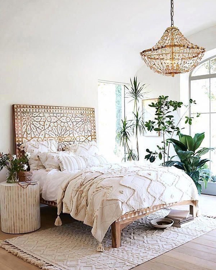 Boho-chic bedroom, carved headboard, chandelier, plants