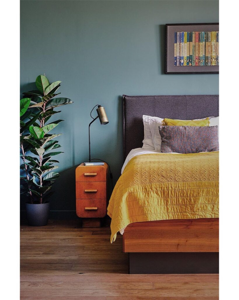 Green bedroom, yellow bedding, wood furniture