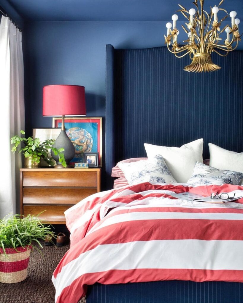 Navy walls, coral bedding, gold chandelier