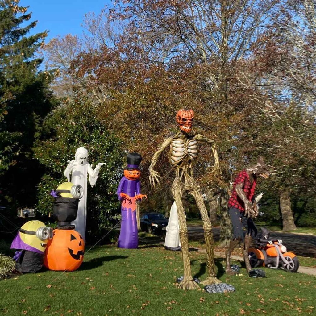 Yard with giant skeleton and Halloween inflatables