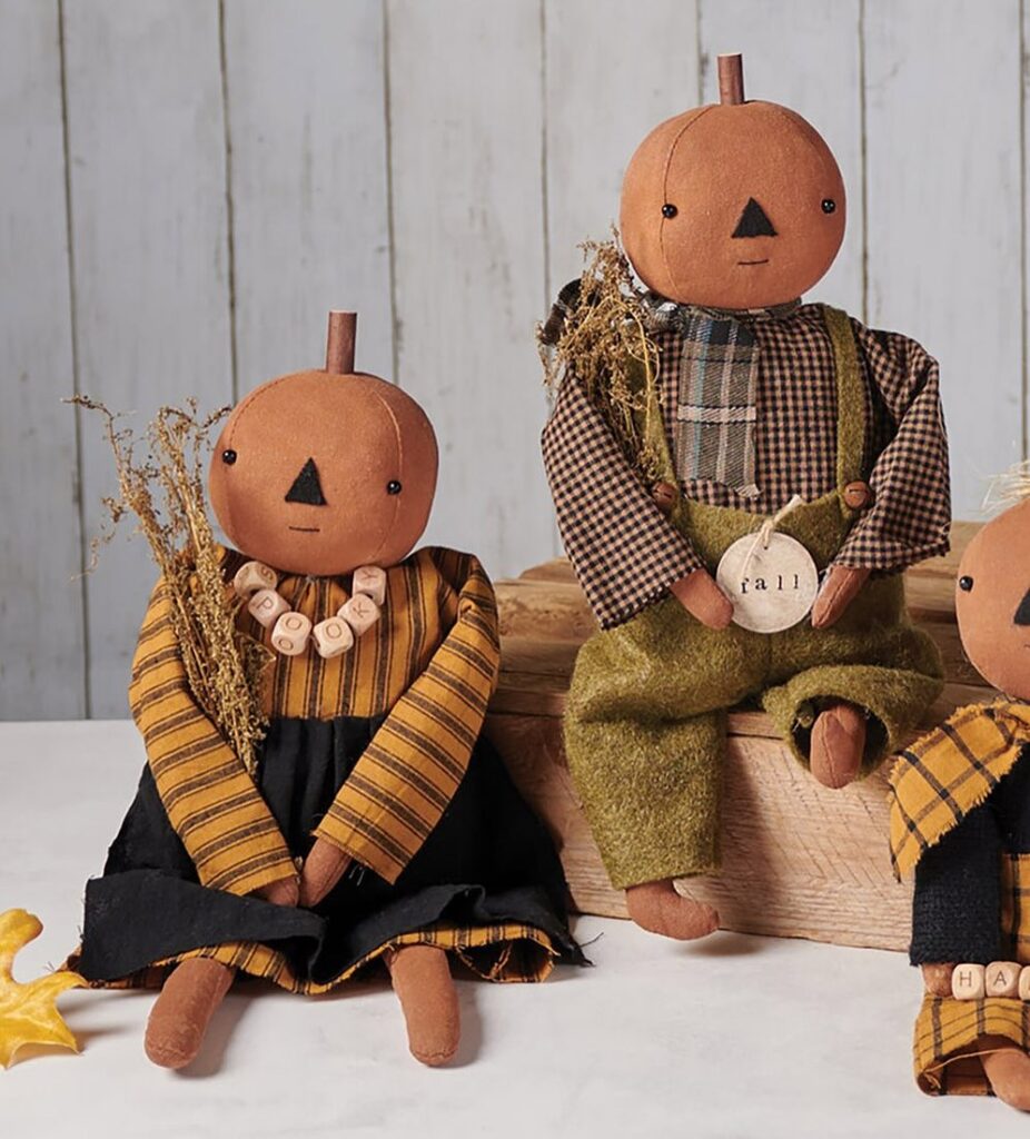 Handmade pumpkin-headed dolls in autumn outfits