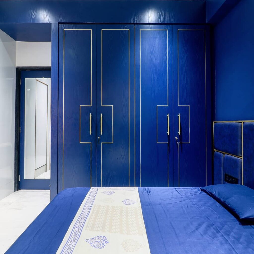 Blue bedroom with gold-trimmed wardrobes