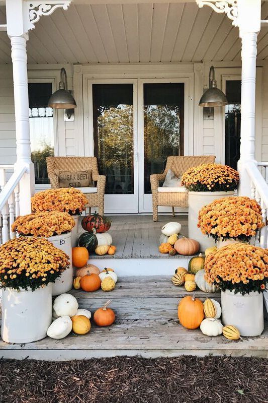 Porch with mums, pumpkins, wicker chairs