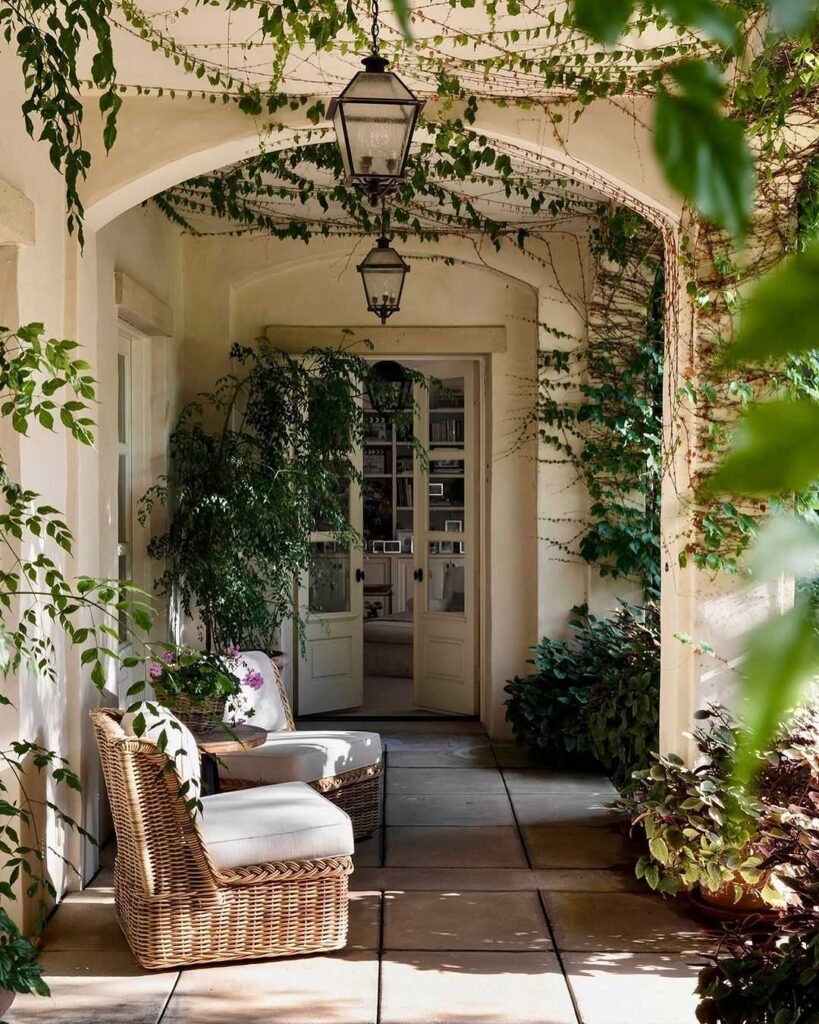 Vine-covered porch with wicker chair and lanterns