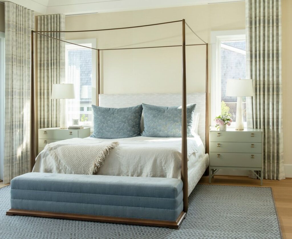 Canopy bed with blue accents, light-filled room