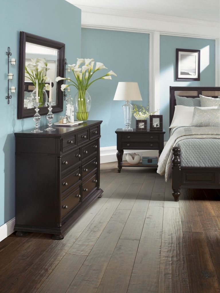 Dark wood furniture, blue walls, elegant bedroom