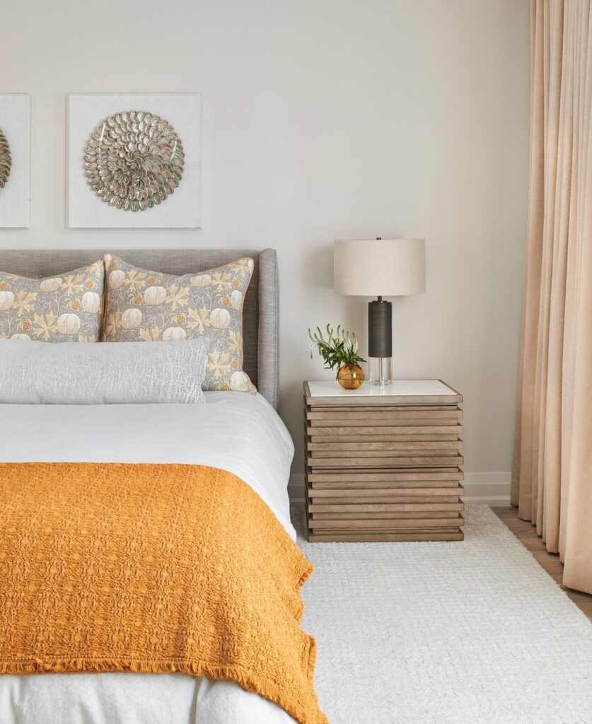 Neutral bedroom with orange accents, shell-inspired art