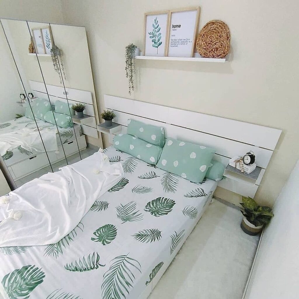 Green-white bedroom with leaf bedding, plants