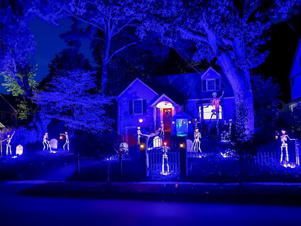 House with blue-lit Halloween skeleton decorations