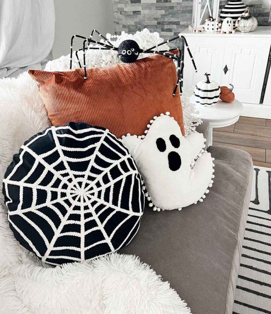 Halloween pillows with spider on cozy sofa