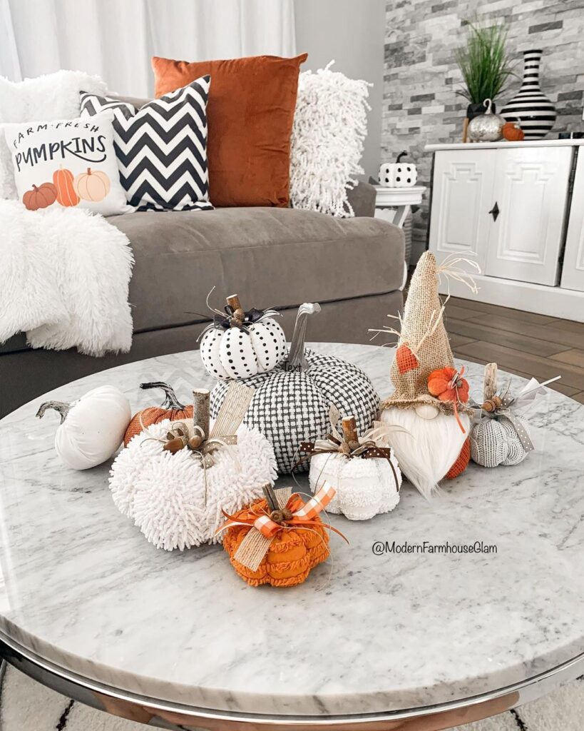 Marble table with diverse pumpkin decorations and fall pillows