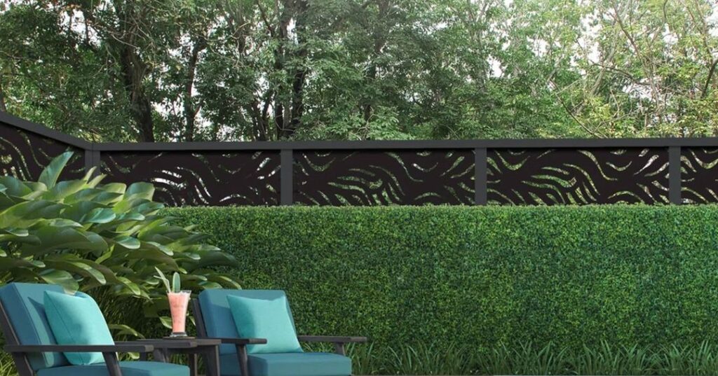 Garden with hedge, decorative fence and blue chairs