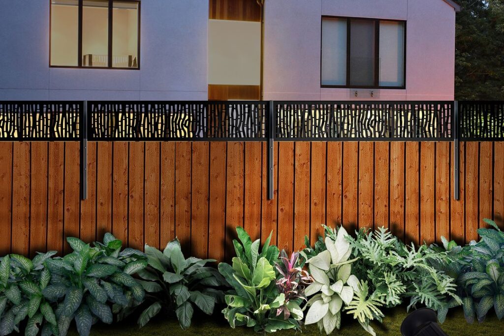 Wooden fence with metal top and tropical plants