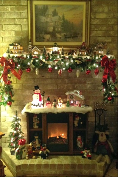 Festive fireplace with miniature village and snowmen