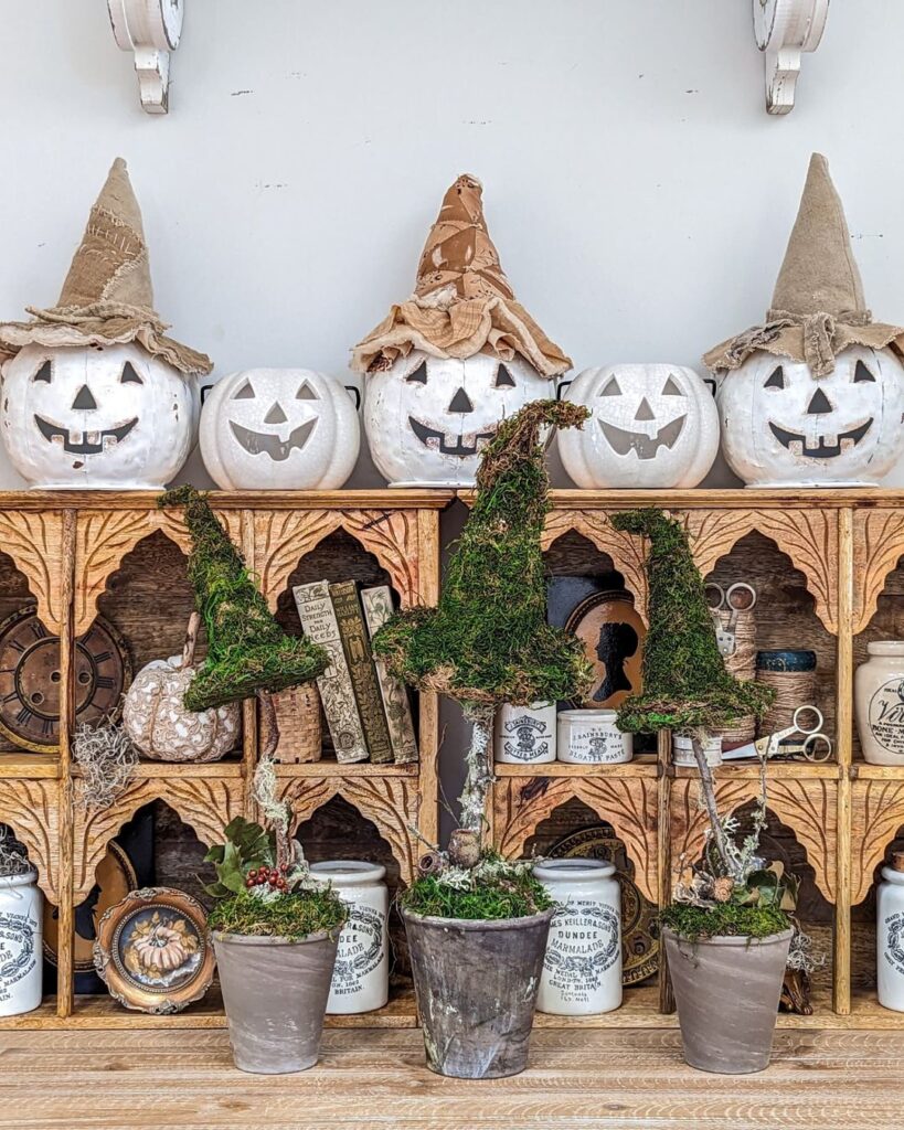 Witch-themed pumpkins on vintage apothecary shelf