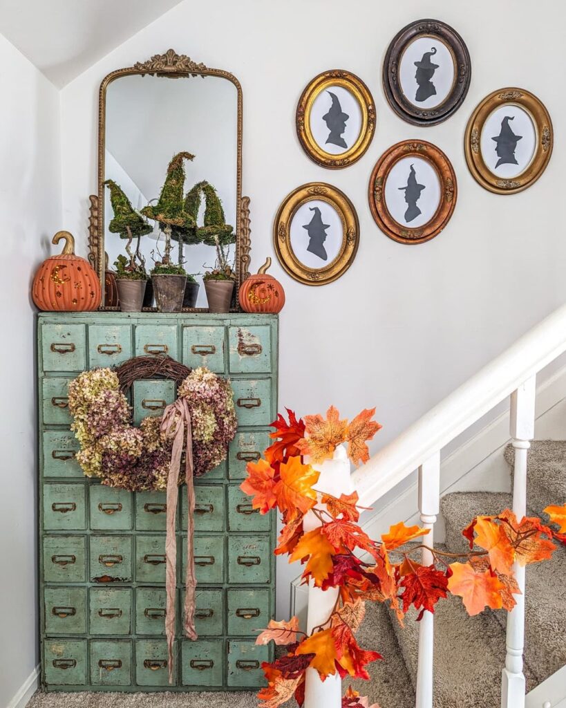 Vintage cabinet with witch-themed Halloween decor and autumn leaves