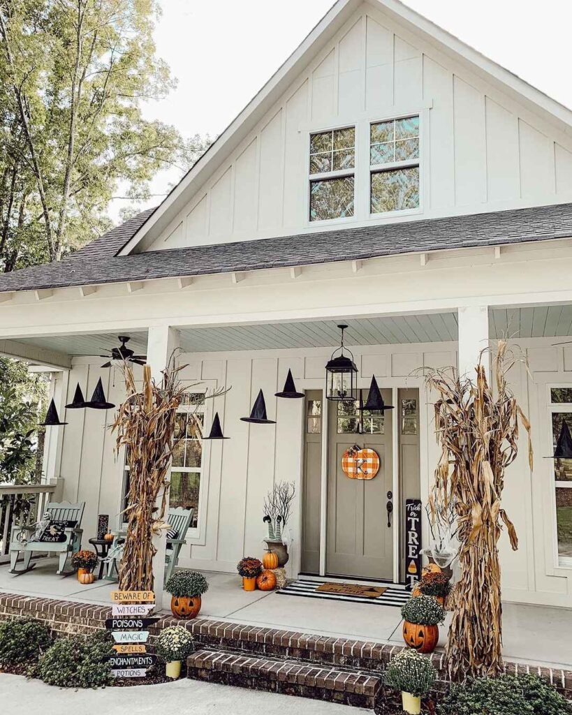 Halloween-decorated farmhouse porch with witches' hats