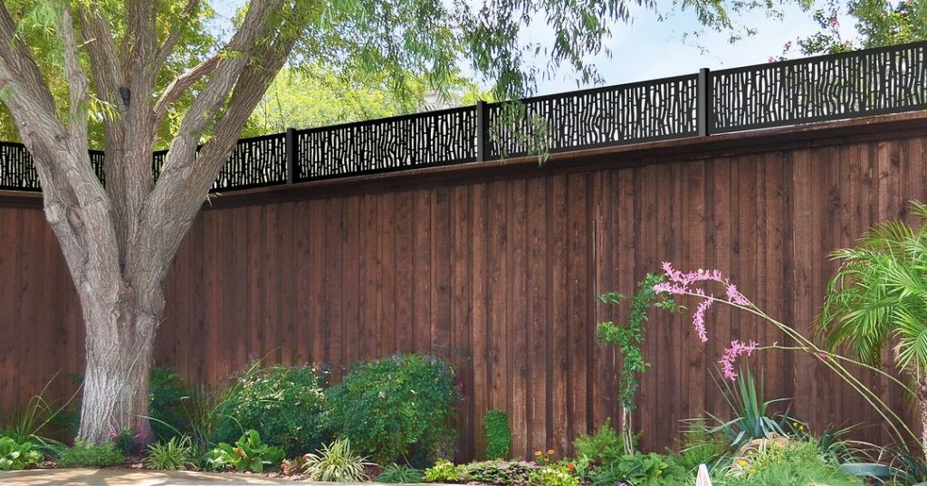 Wooden fence with decorative top and garden