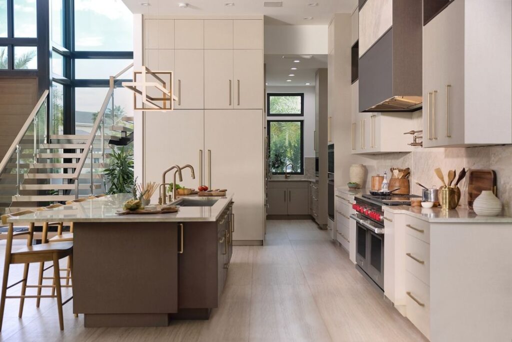 Bright kitchen with island, glass staircase, and palm tree views.