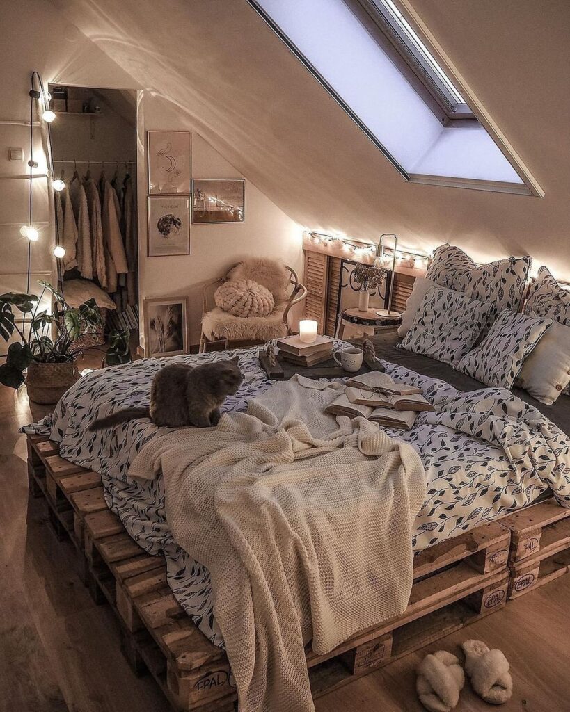 Cozy attic bedroom with pallet bed fairy lights and cat