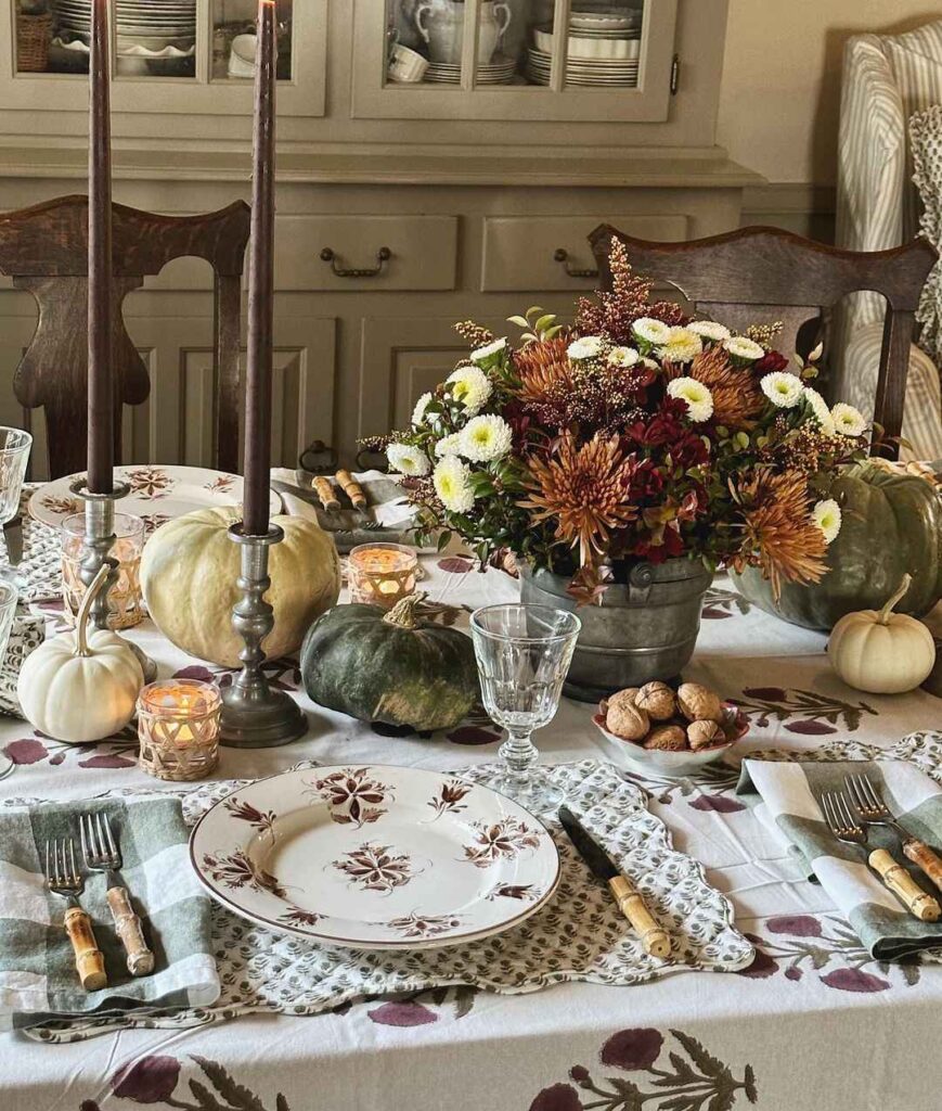 Thanksgiving table with fall flowers pumpkins and candles