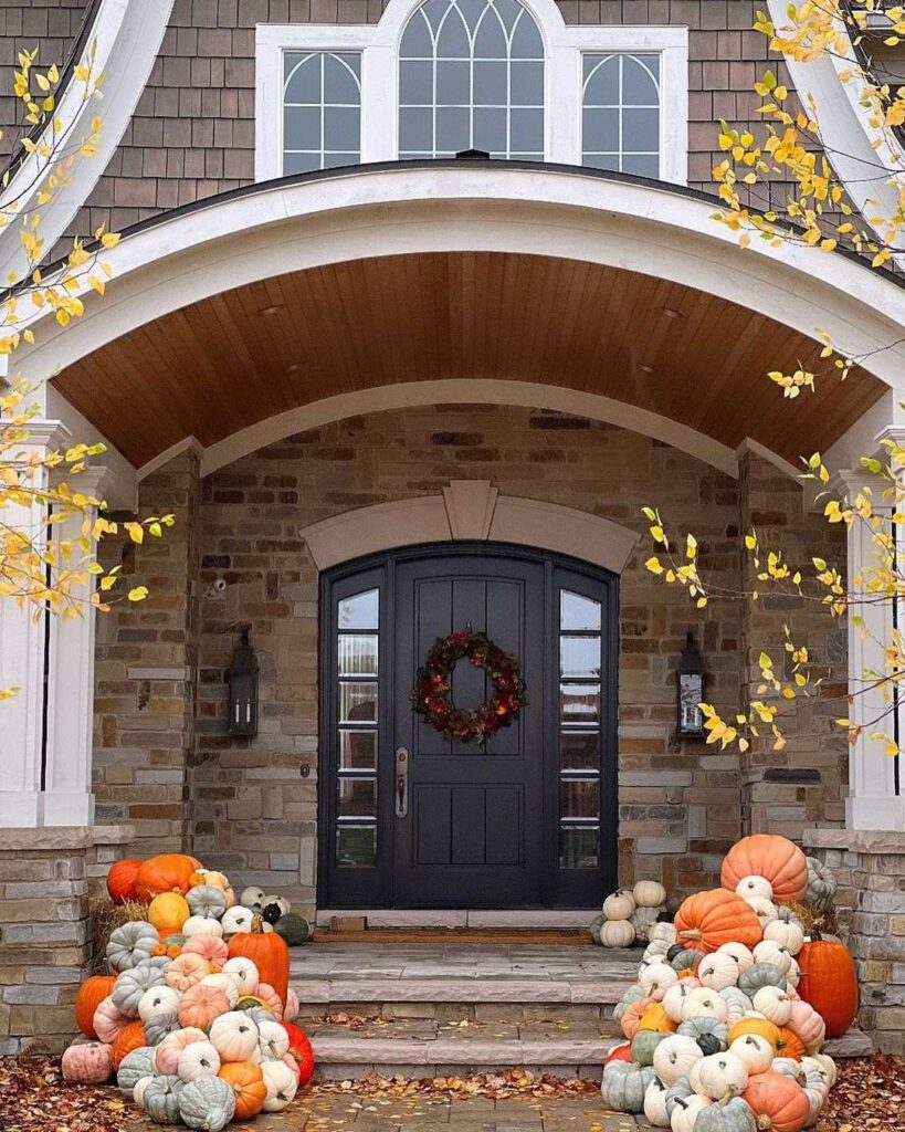 Stone archway entrance decorated with pumpkins and fall foliage