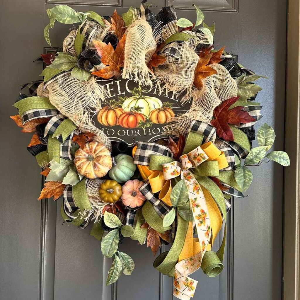 Autumn wreath with pumpkins and Welcome sign.