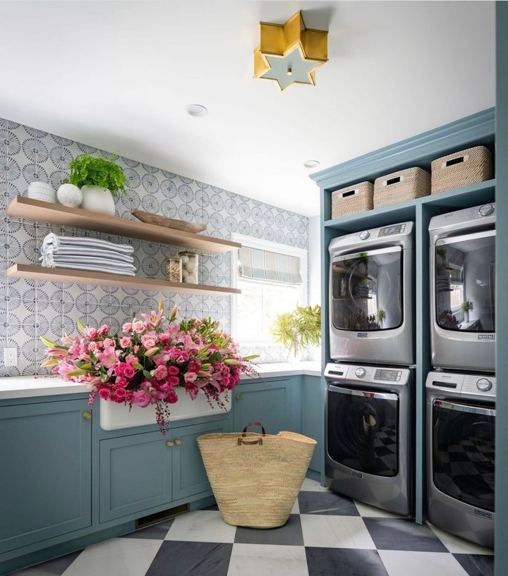 Blue laundry room with pink flowers and stacked appliances