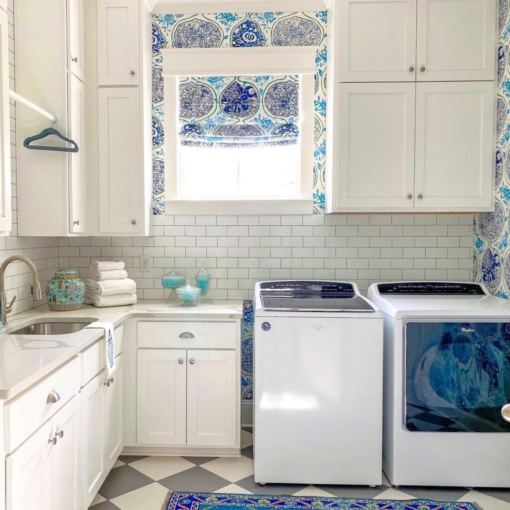 Bright blue-accented laundry room with top-loaders.