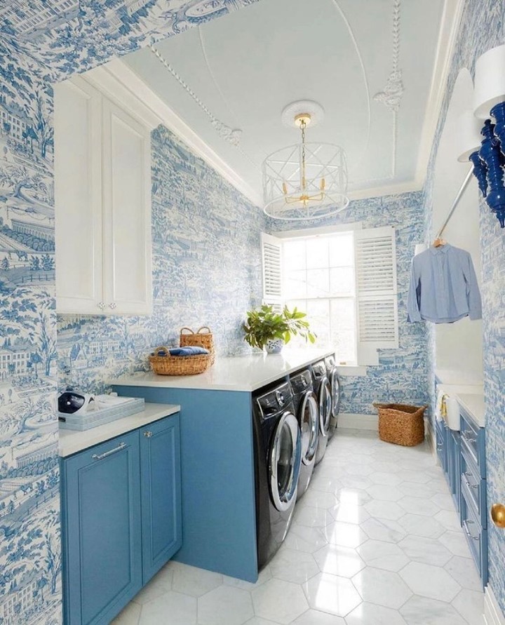 Blue and white laundry room with toile wallpaper and modern appliances.