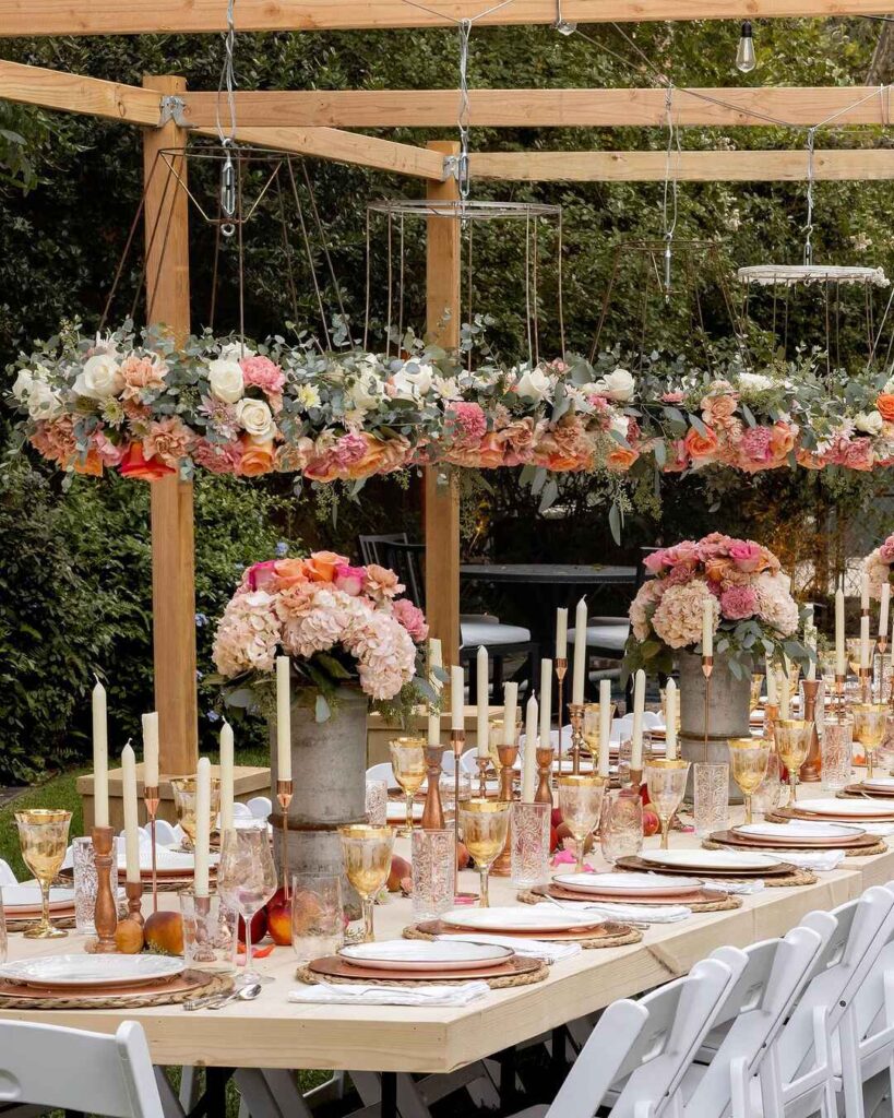 Outdoor Thanksgiving table under floral-adorned pergola with candles