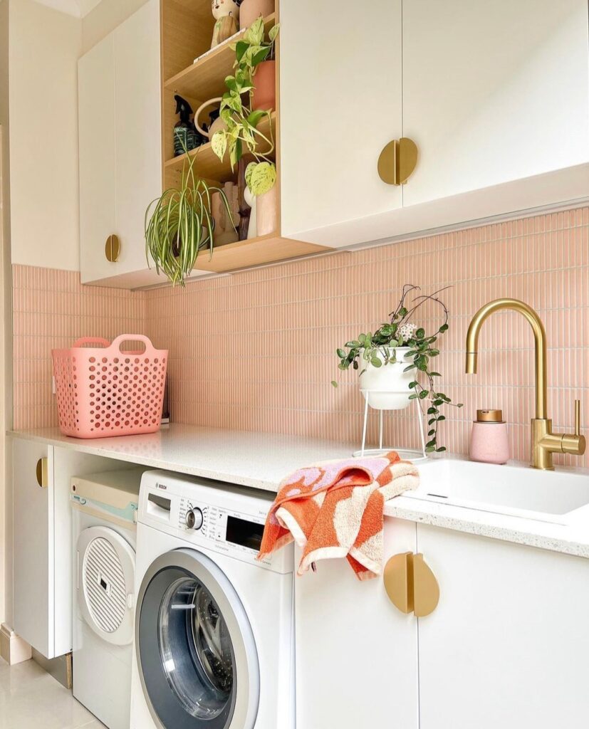 Pink-tiled laundry room with white cabinets and potted plants