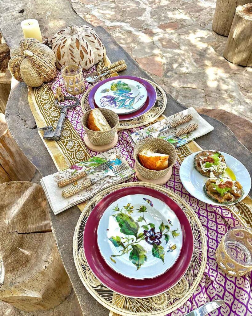 Outdoor Thanksgiving table with bohemian decor and colorful dishes