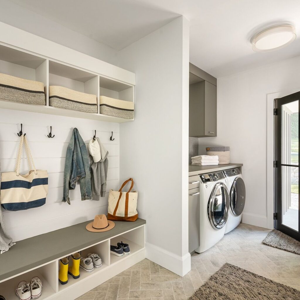 White laundry room with adjoining mudroom area featuring built-in storage.