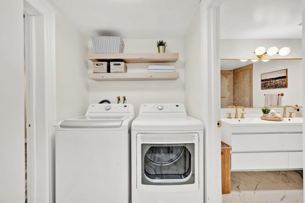 White laundry nook connected to modern bathroom