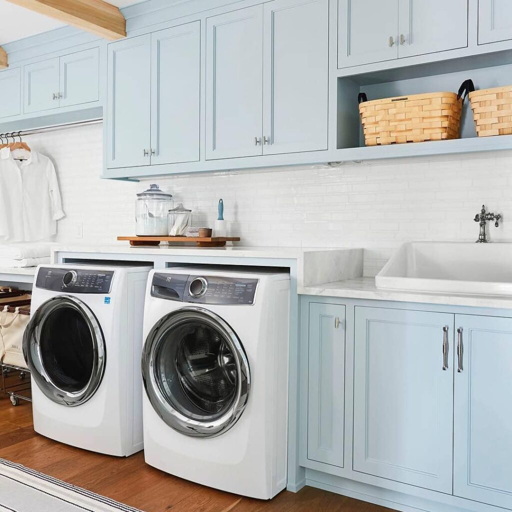 Light blue laundry room with white appliances and wooden accents.