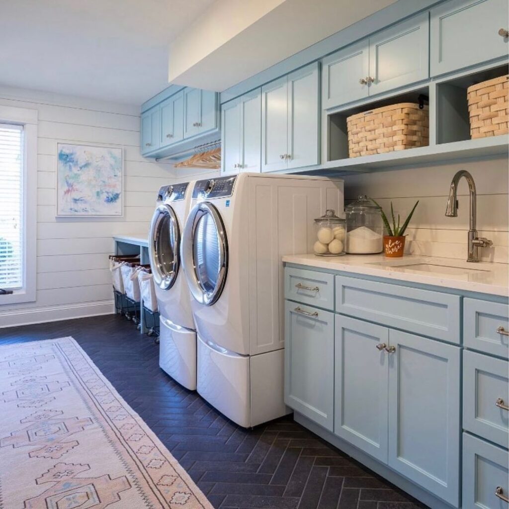 Luxury laundry room with blue cabinets and modern appliances.